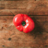 Ugly tomatoes on wooden background. Concept of zero waste production. Top view. Copy space. Non gmo vegetables Pomodoro Antico di Barbastro semi