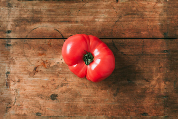 Ugly tomatoes on wooden background. Concept of zero waste production. Top view. Copy space. Non gmo vegetables Pomodoro Antico di Barbastro semi